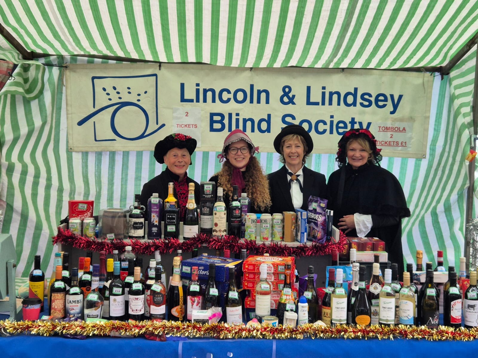 Fundraising tombola stall on Louth Christmas market with four LLBS staff behind the stall.
